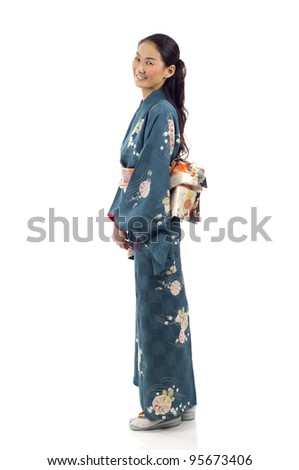 Side view of a pretty smiling Japanese kimono woman standing isolated over white background