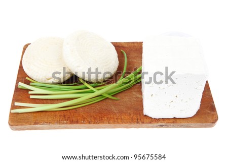 diet food : greek feta white cheese served on small wooden plate with olive oil isolated over white background