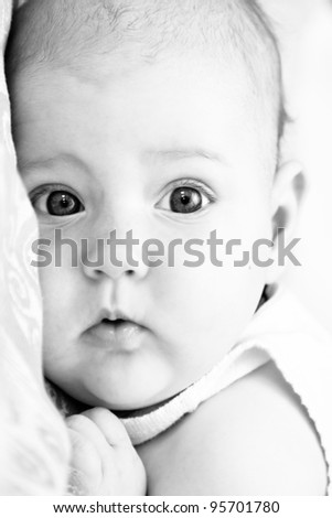 newborn baby looks surprised with big eyes. Black and white photo