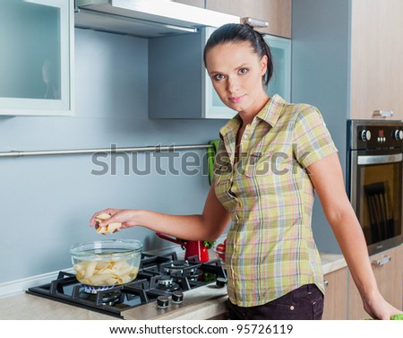 Portrait of a girl cooking at the kitchen. Vertical view