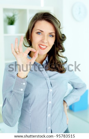 Young woman making an OK gesture and looking at camera