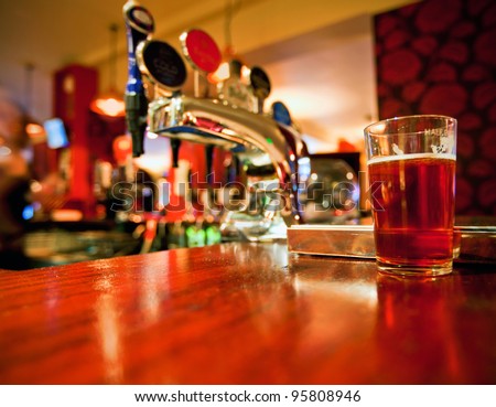 Pint of beer on a bar in a traditional style English pub Royalty-Free Stock Photo #95808946