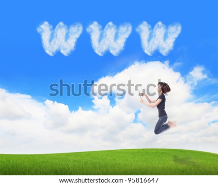 Young beauty happy jump and using tablet pc in the air on meadow with www cloud sky background , model is a cute asian, for cloud computing concept