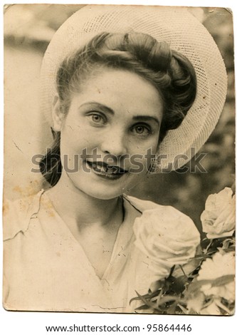 USSR - CIRCA 1947: Portrait of a young beautiful woman with white roses, circa 1947