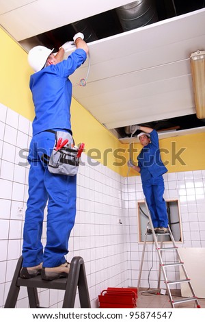 Electrician wiring a large tiled room