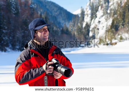 Portrait of a professional nature photographer outdoor in the winter landscape