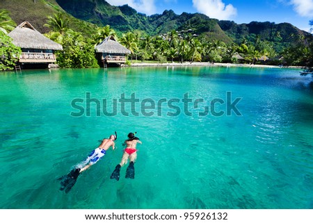 Young couple snorkeling in clean water over coral reef Royalty-Free Stock Photo #95926132
