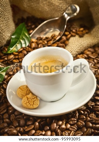 Espresso cup with fresh brewed coffee and beans