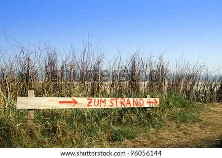 A wooden sign with the letters to the beach