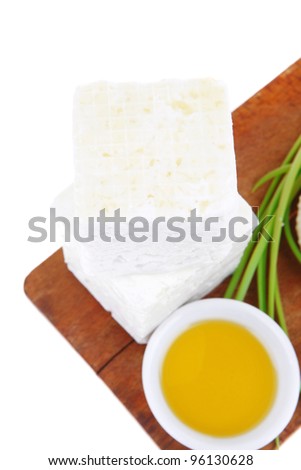dairy product : raw soft mediterranean feta white cheese cubes and round on wooden plate isolated over white background