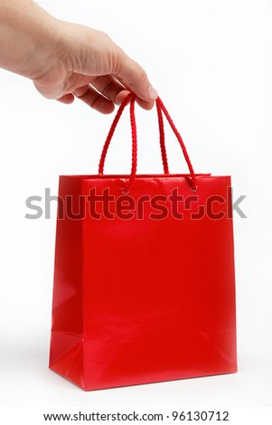 Red gift bag in the women's hand on a white background.