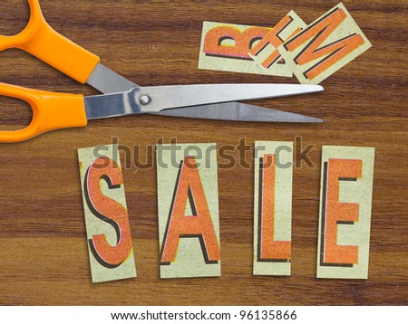 Sale in cut letters with scissors for discount concept