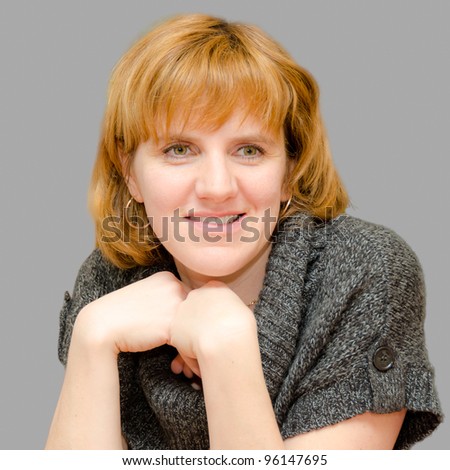 Portrait of a girl in woolen sweater isolated on grey background.