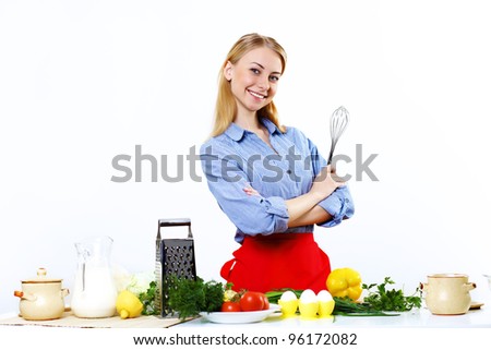 Young happy woman cooking fresh meal at home