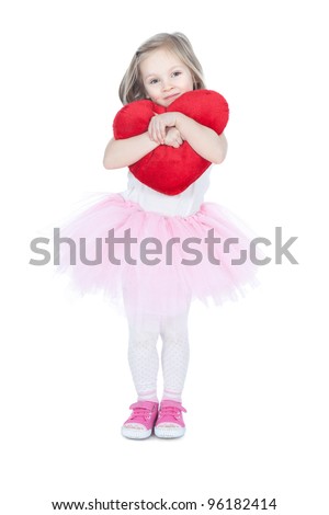 Pretty little blonde girl holding the heart cushion over white