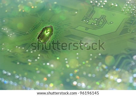 A nicely shimmering bug, in real greenish color,  in front of a motherboard, showing a system error, through this picture