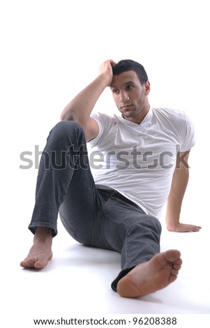 portrait of relaxed young man dressed in white shirt and jeans isolated over white background in studio