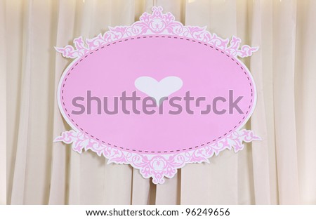 Pink backdrop have white heart at the center on curtain background.