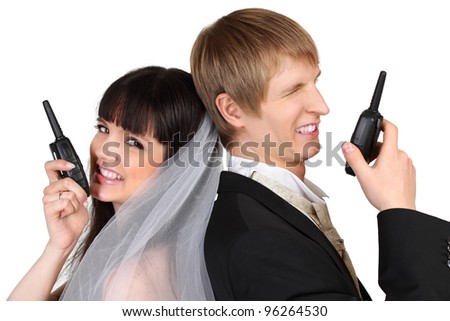 Dissatisfied young groom and bride speak on radio isolated on white background