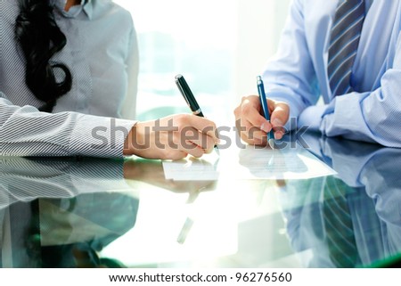 Two business people signing a document