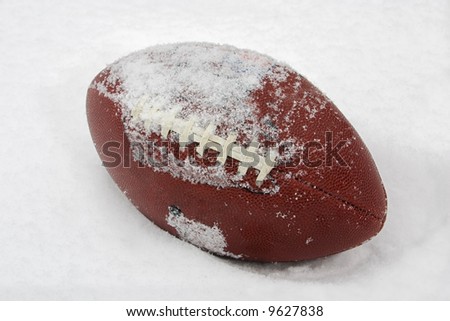 a football covered with snow and laying in the snow