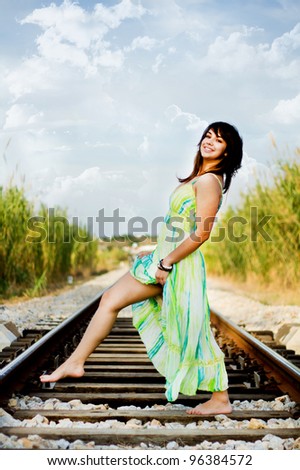 View of a beautiful girl with a spring dress on a railway.
