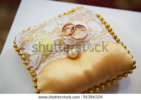 Wedding rings on a satin pillow with lace