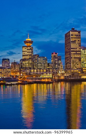 City at night, panoramic scene of downtown reflected in water, Vancouver, Canada.