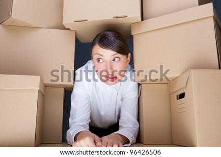 Portrait of young woman surrounded by lots of boxes. Lots of work concept.