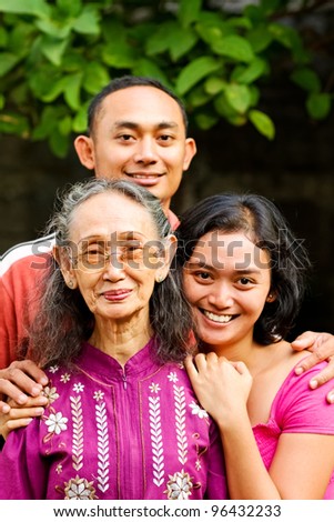 family portrait of asian ethnic elderly woman with young adult son and daughter