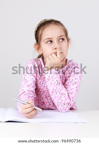 Schoolgirl making homework and thinking