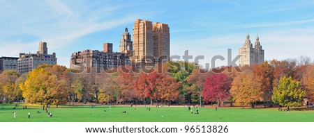 New York City Central Park panorama at autumn in midtown Manhattan with colorful foliage and people on lawn
