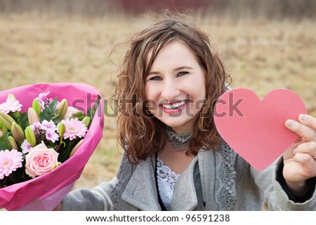 Beautiful smiling woman showing her Valentine's gifts