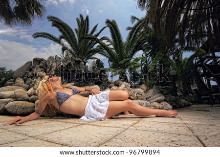fashion bikini model under palm tree