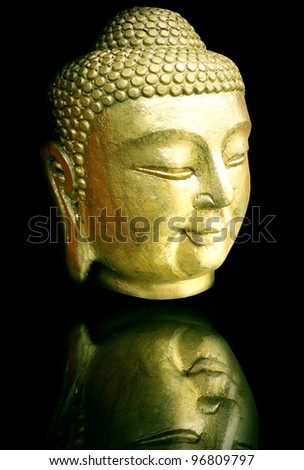 Photo of a beautiful golden head's statue of Buddha in black background