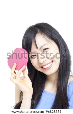 Cute young woman holding pink heart symbol, isolated on white background