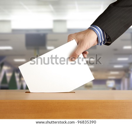 Hand putting a voting ballot in a slot of box Royalty-Free Stock Photo #96835390