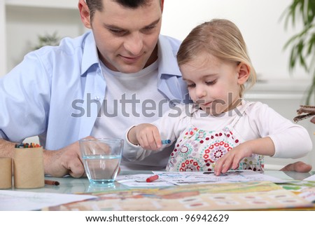 Young girl coloring with dad