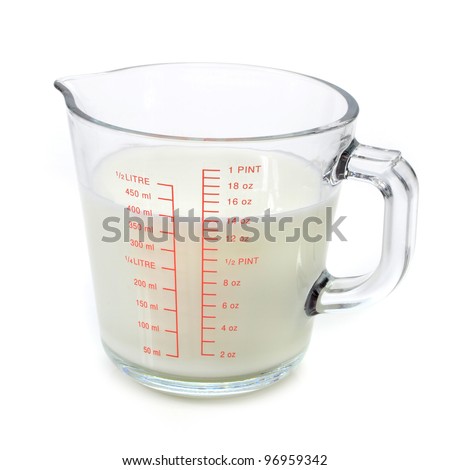 Milk in measuring cup on white background Royalty-Free Stock Photo #96959342