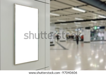 One big vertical / portrait orientation blank billboard on modern white wall with subway concourse background