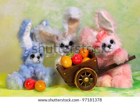 Three Easter bunny rabbit with Easter basket full of decorated Easter eggs.