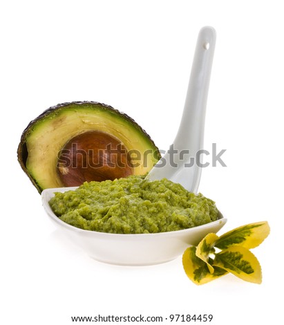 Fresh guacamole in a white bowl with a spoon  isolated on white background