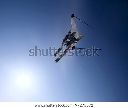 Freeride skier jumping high in the blue sky