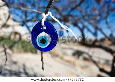 Evil eye charms hang from a bare tree in Cappadocia, Turkey.