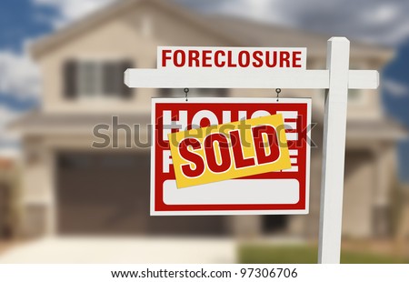Sold Foreclosure Home For Sale Sign and House with Dramatic Sky Background.