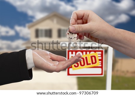 Handing Over the House Keys in Front of Real Estate Sign and Sold New Home.