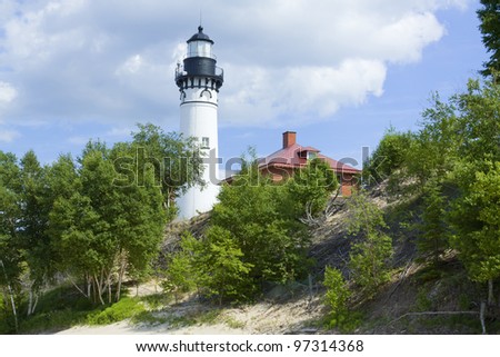 Old white lighthouse on hill in hot summer day