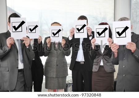 Successful team holding check mark vote sign