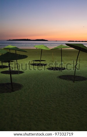 Beach bar umbrellas shadows after evening sunset