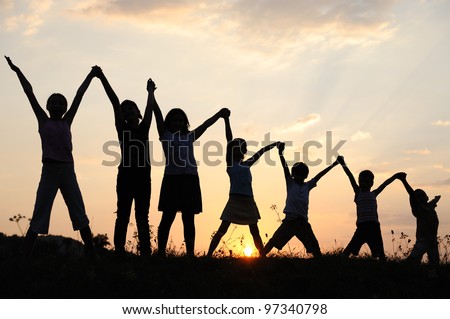Several children generations with arms up in nature